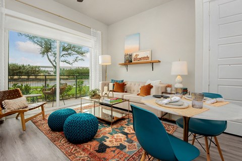 a living room with a large window and a table and chairs